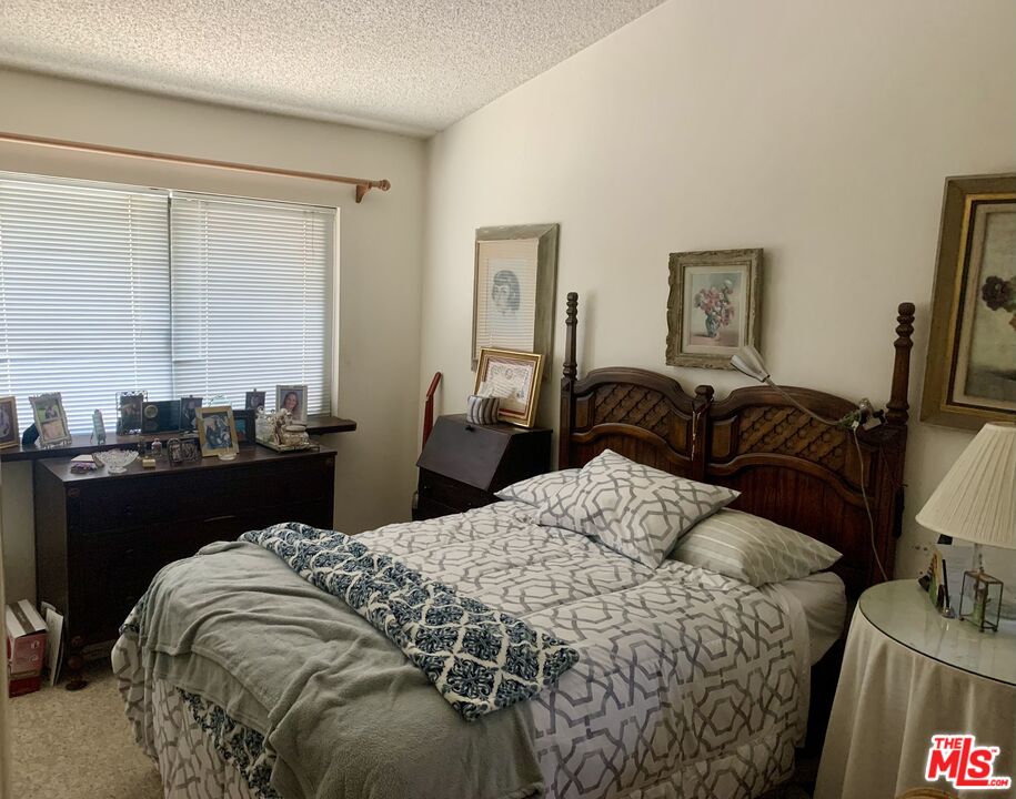 7312 Corbin Avenue, Unit M Reseda, CA 91335 - Photo 5 of 18 a bed sitting in a bedroom next to a window with computer