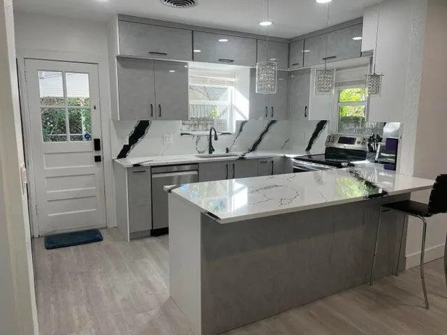 a kitchen that has a sink a stove and a refrigerator