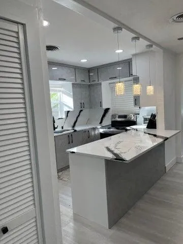 a kitchen with stainless steel appliances granite countertop a sink and a stove
