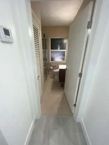 a view of a hallway with a kitchen