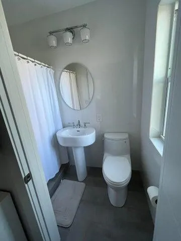 a bathroom with a toilet sink and mirror