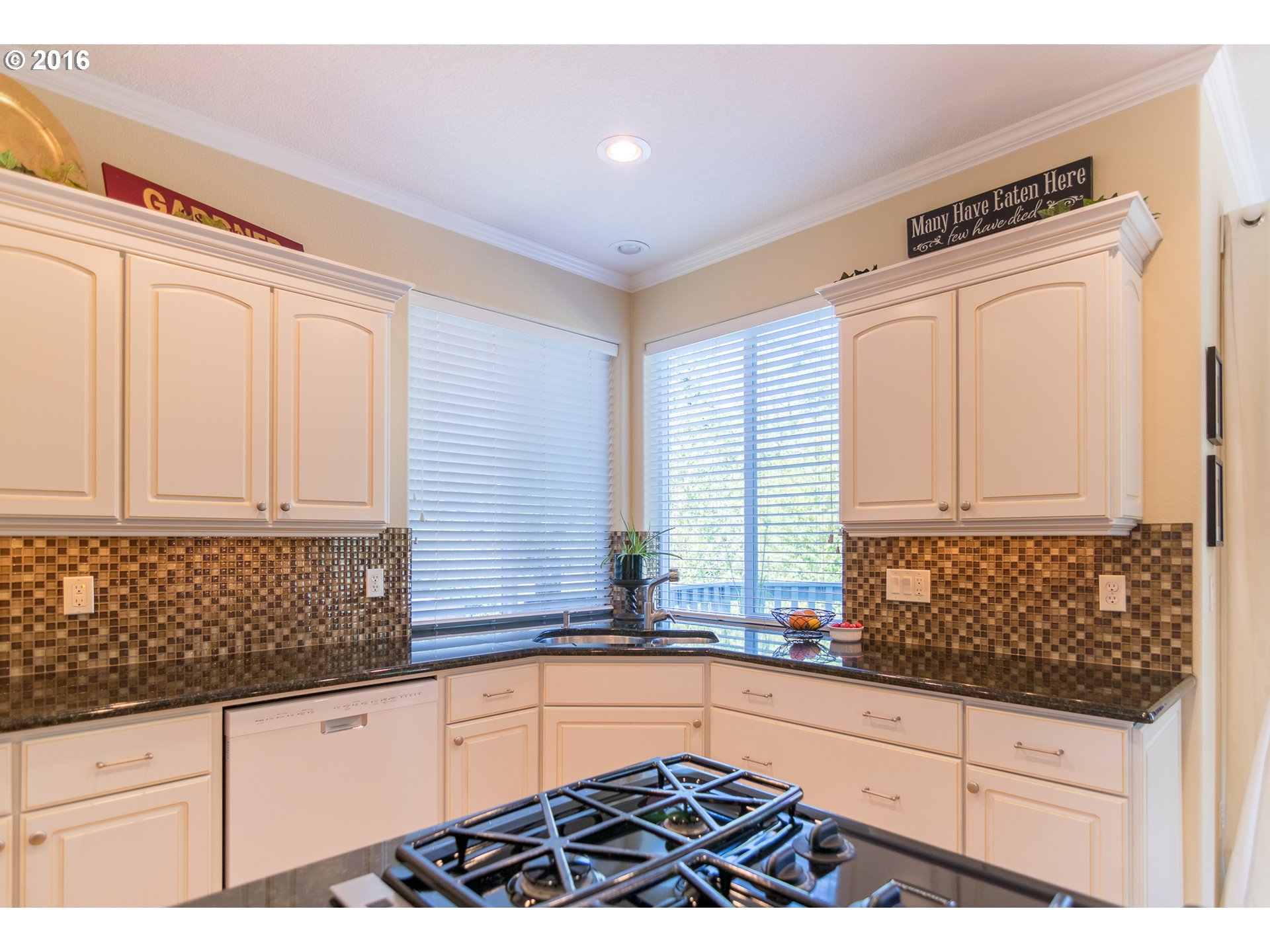15806 Southwest Colyer Way Tigard, OR 97224 - Photo 12 of 32 a kitchen with granite countertop a sink and a white wooden cabinets