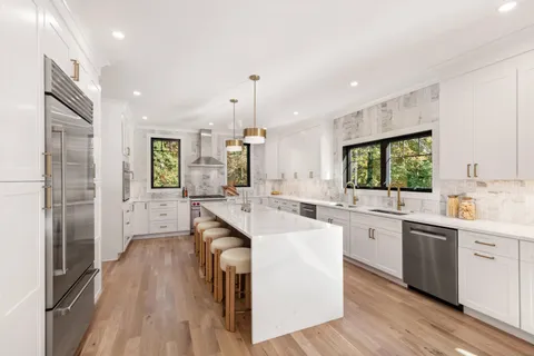 a large kitchen with kitchen island a sink stainless steel appliances and cabinets