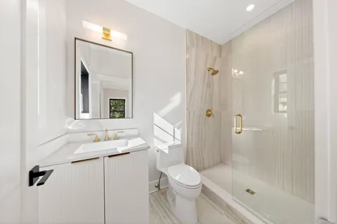 a bathroom with a granite countertop sink a toilet and shower