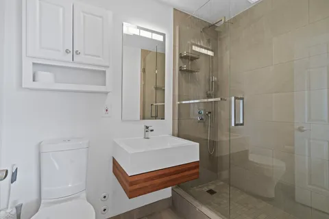 a bathroom with a sink a toilet and shower