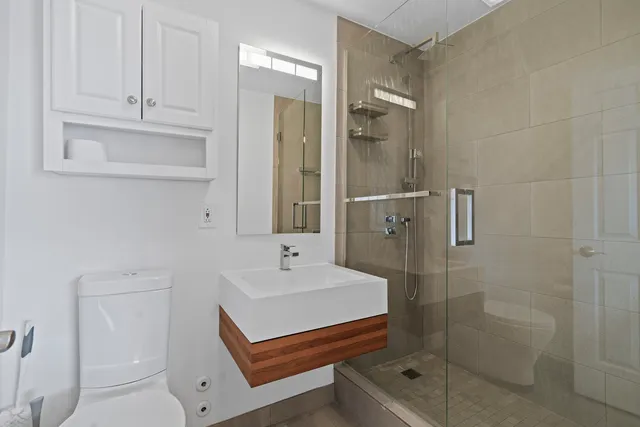 a bathroom with a sink a toilet and shower