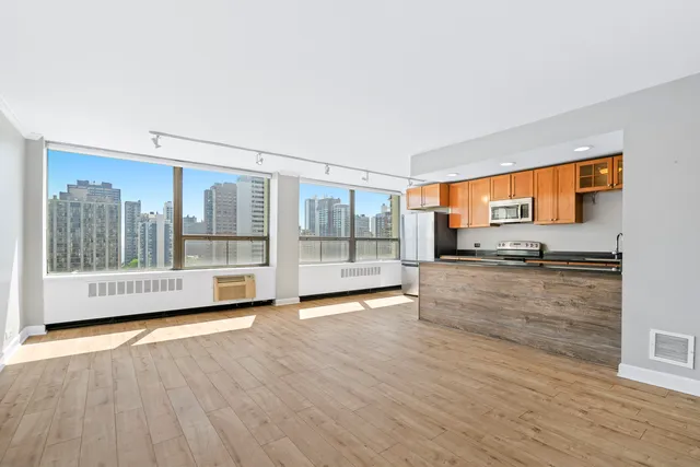 a view of a living room with hardwood floor and a large window