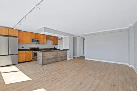 a kitchen with stainless steel appliances kitchen island granite countertop a stove a sink and a refrigerator