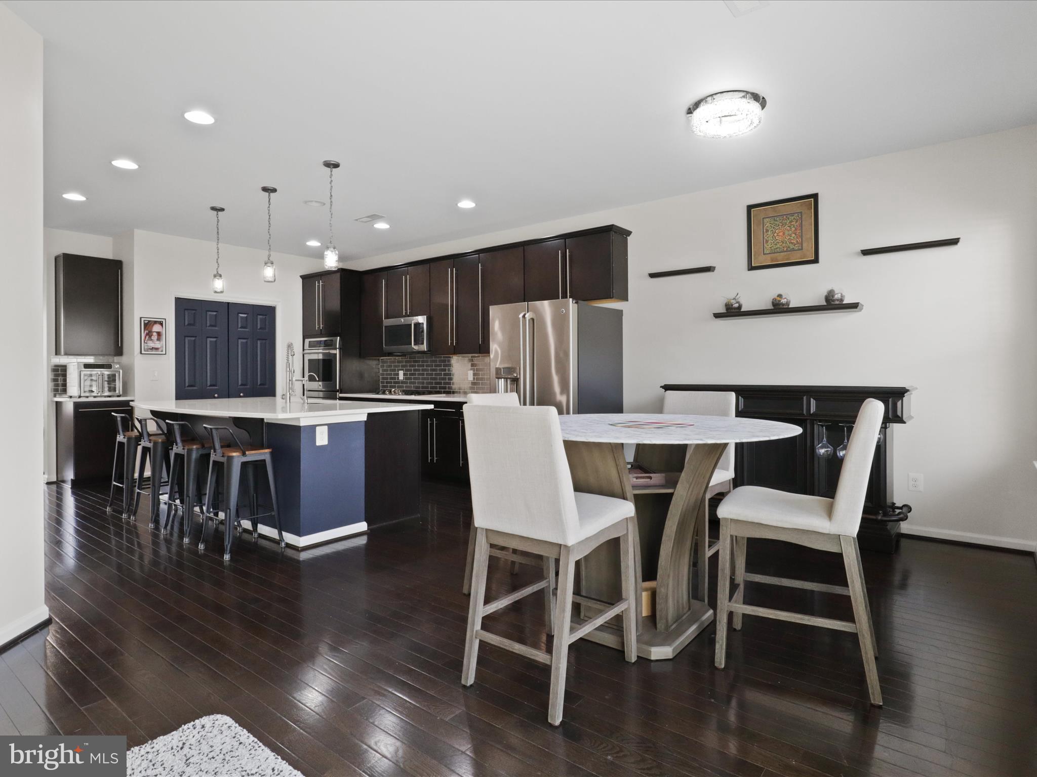 44021 Eastgate View Drive Chantilly, VA 20152 - Photo 13 of 30 a view of a dining room with furniture wooden floor and a kitchen view