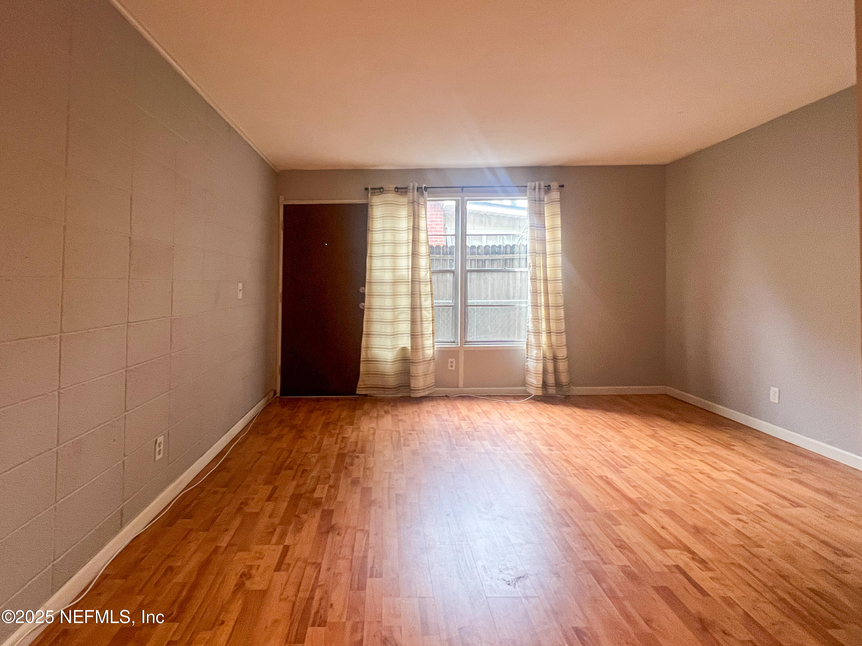 2960 Remington Street, Unit 2 Jacksonville, FL 32205 - Photo 3 of 14 a view of an empty room with wooden floor and a window