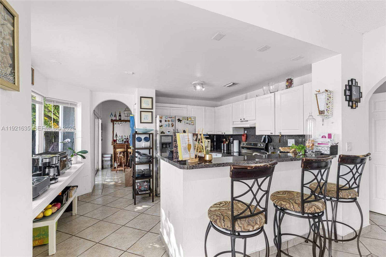 4687 Southwest 153rd Court Miami, FL 33185 - Photo 16 of 40 a kitchen with stainless steel appliances kitchen island granite countertop a table and chairs