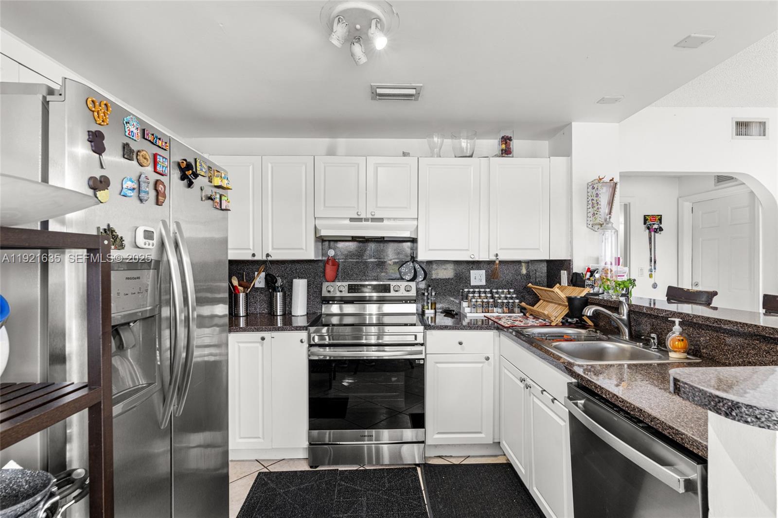 4687 Southwest 153rd Court Miami, FL 33185 - Photo 17 of 40 a kitchen with stainless steel appliances a stove sink refrigerator and cabinets