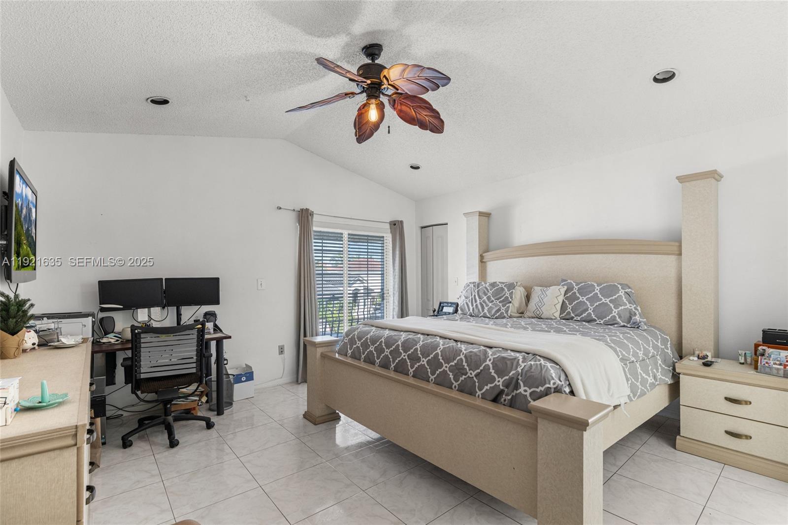 4687 Southwest 153rd Court Miami, FL 33185 - Photo 25 of 40 a bedroom with a bed a computer on the desk and a chandelier