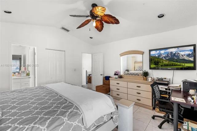 a bedroom with a large bed and a flat screen tv