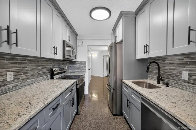 a kitchen with stainless steel appliances granite countertop a stove and a microwave