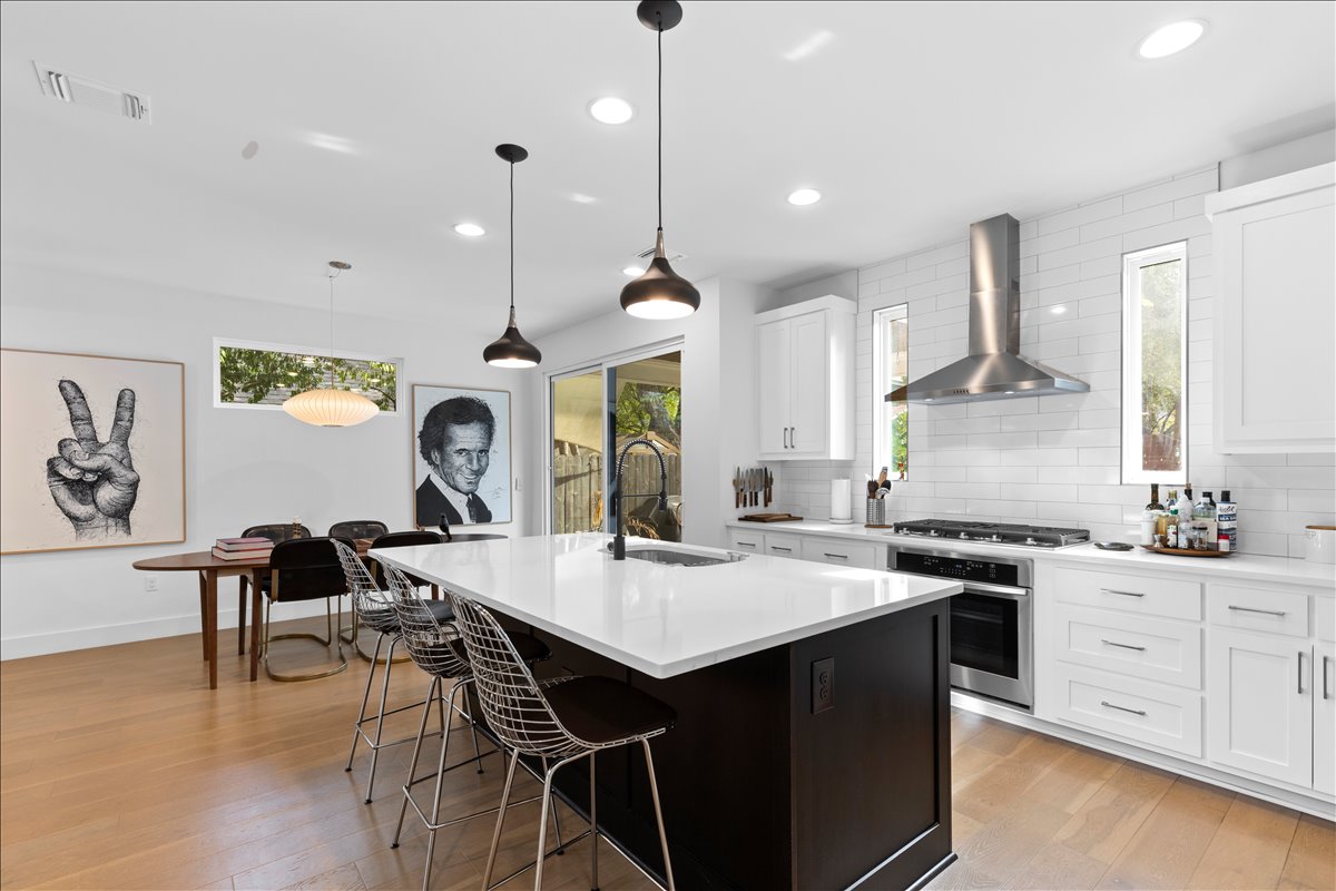 4201 Clawson Road Austin, TX 78704 - Photo 5 of 25 a kitchen with a stove a sink a dining table and chairs