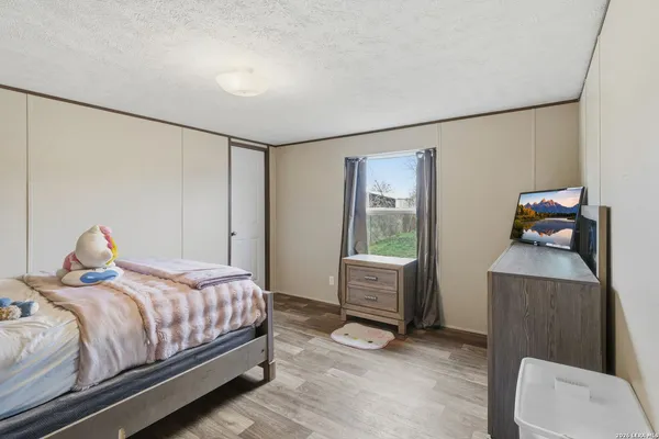 a bedroom with a bed and wooden floor