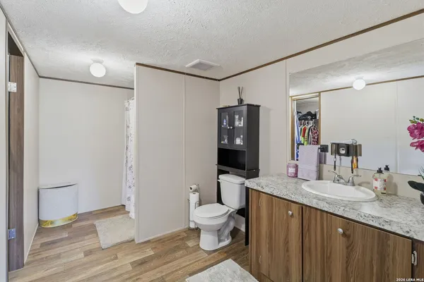 a bathroom with a granite countertop sink toilet and shower