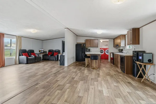 a living room with lots of furniture and a kitchen view