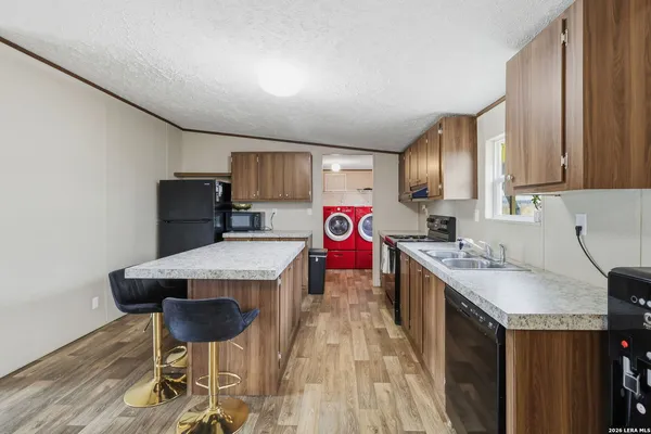 a kitchen that has a table chairs in it and wooden floors
