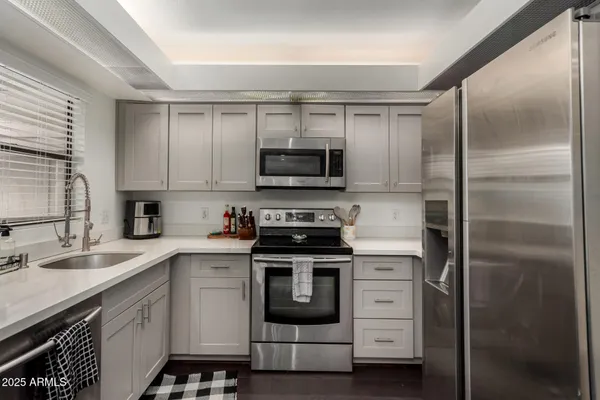 a kitchen with white cabinets and a stove top oven