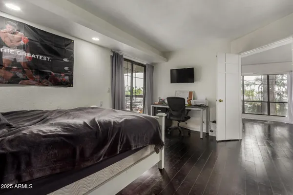 a bedroom with a bed and wooden floor