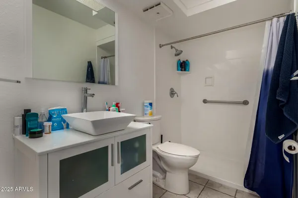 a bathroom with a sink a toilet and a mirror