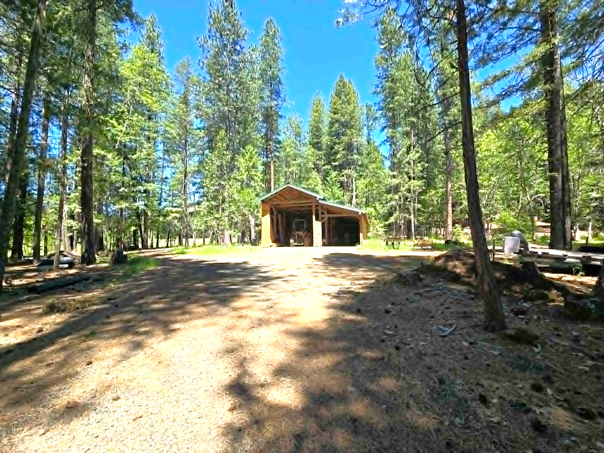 836 Ulrich Road Prospect, OR 97536 - Photo 34 of 47 a backyard of a house with large trees and outdoor seating