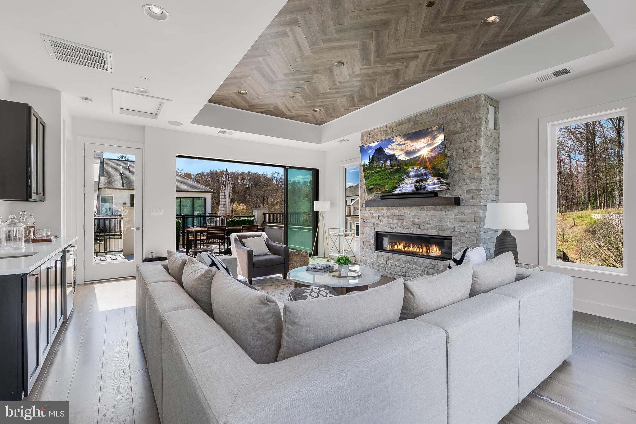 8201 River Road Bethesda, MD 20817 - Photo 31 of 50 a living room with furniture a fireplace and a flat screen tv