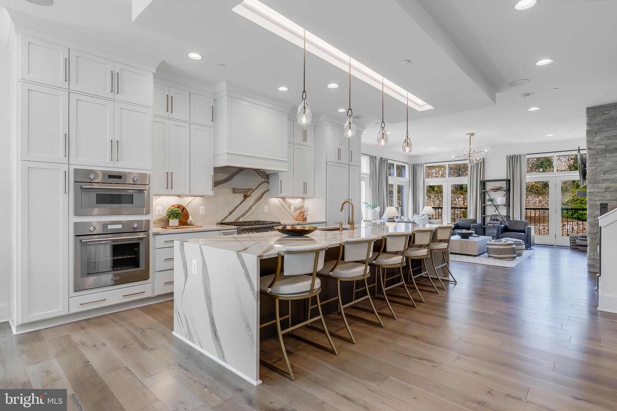 8201 River Road Bethesda, MD 20817 - Photo 9 of 50 a open kitchen with stainless steel appliances kitchen island granite countertop a stove a sink a dining table and chairs with wooden floor