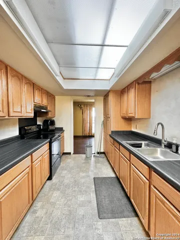 a large kitchen with stainless steel appliances granite countertop a stove a sink dishwasher and a refrigerator