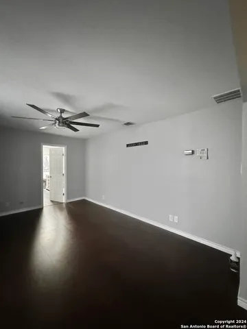 an empty room with a ceiling fan and window