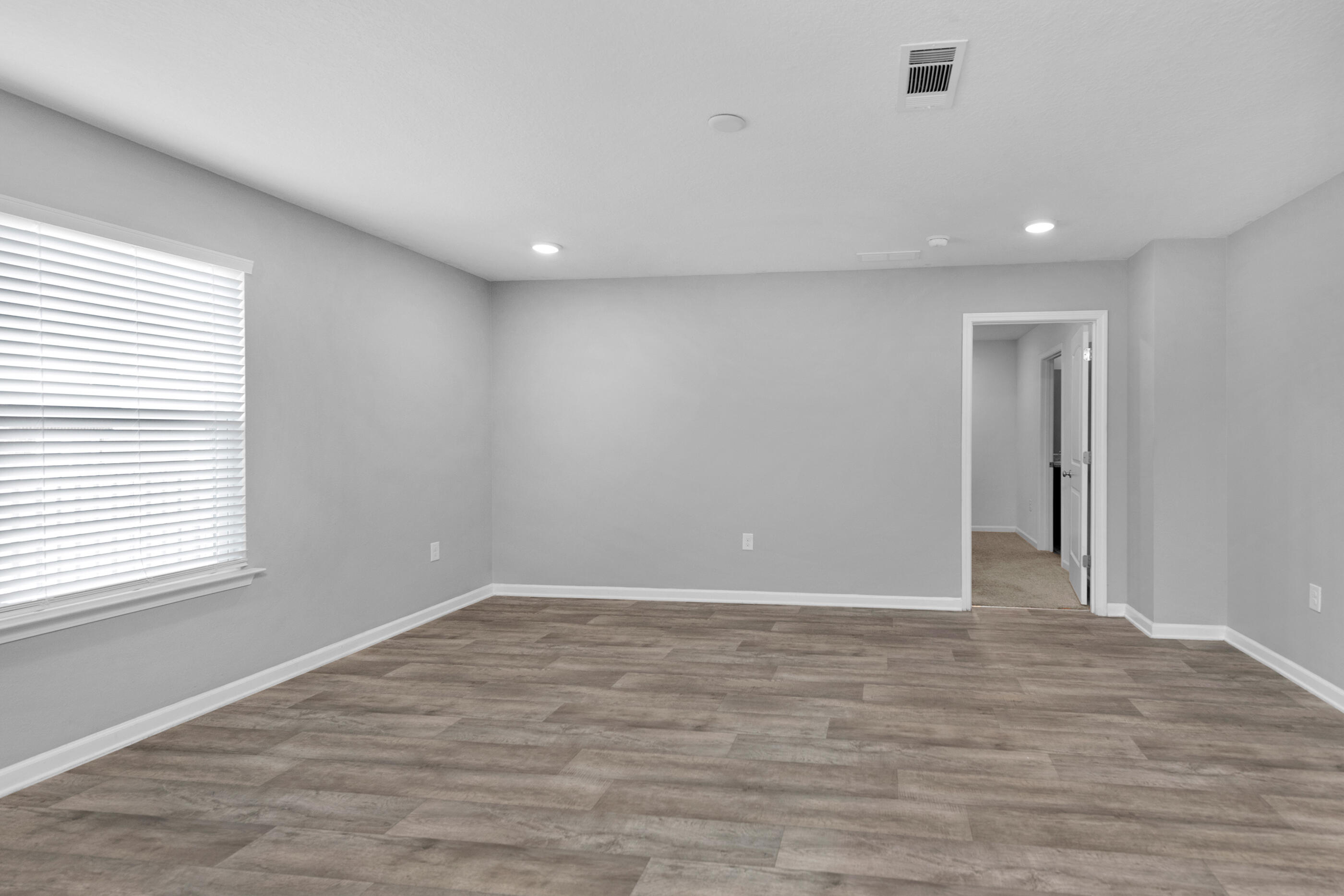 812 Moorhen Way Crestview, FL 32539 - Photo 11 of 22 a view of an empty room with wooden floor and a window
