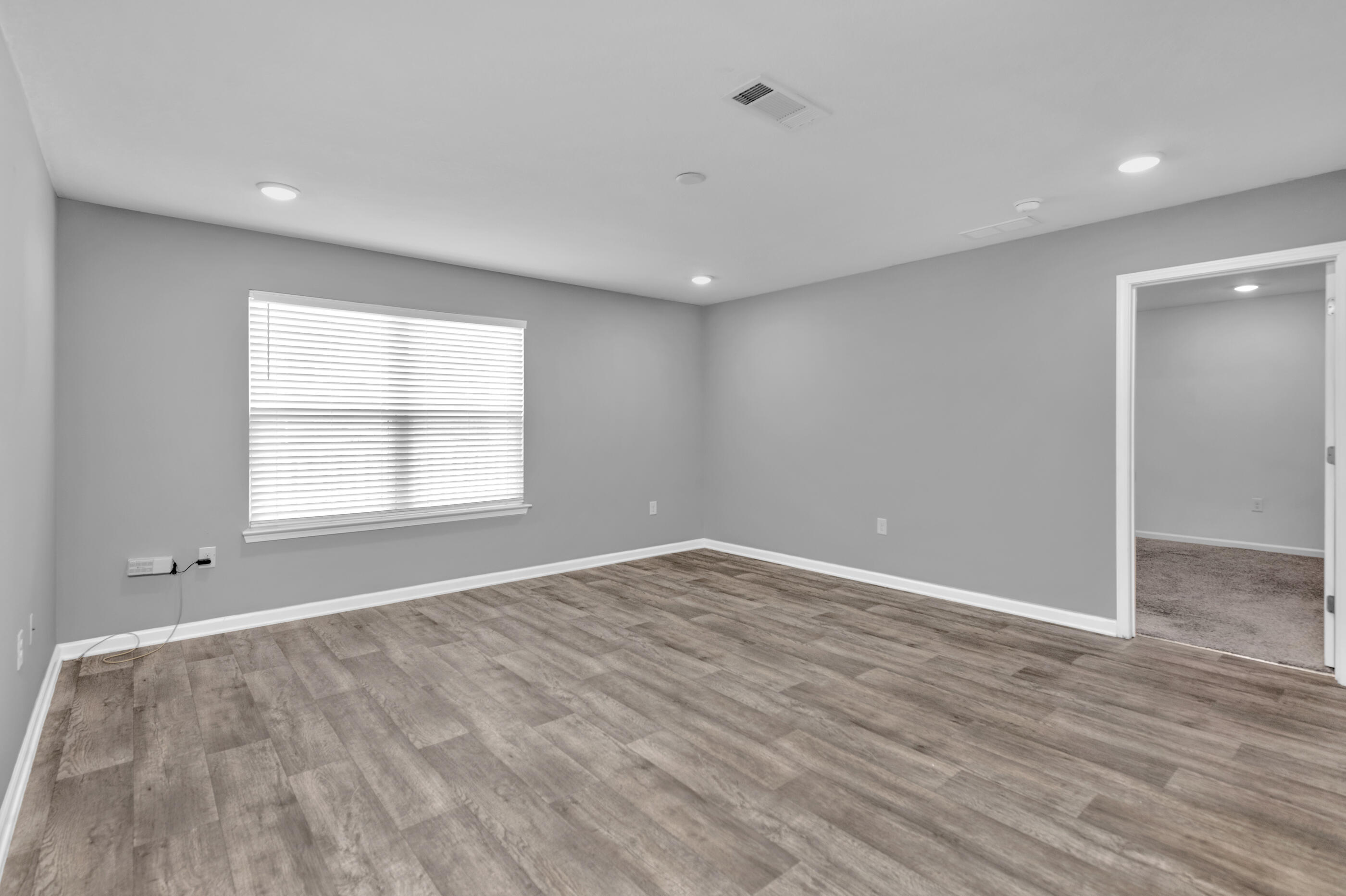 812 Moorhen Way Crestview, FL 32539 - Photo 10 of 22 wooden floor in an empty room with a window