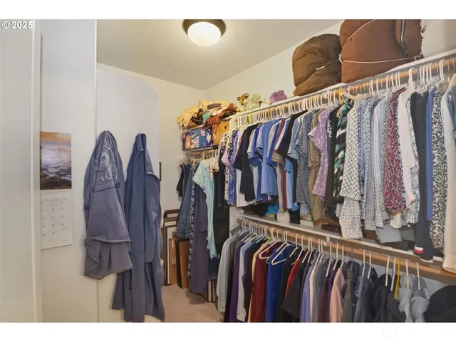 a view of walk in closet with clothes and shoes
