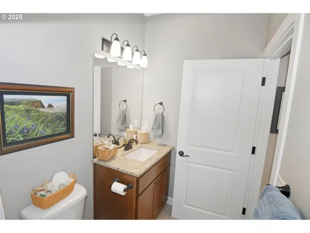 a bathroom with a sink mirror and a painting on the wall