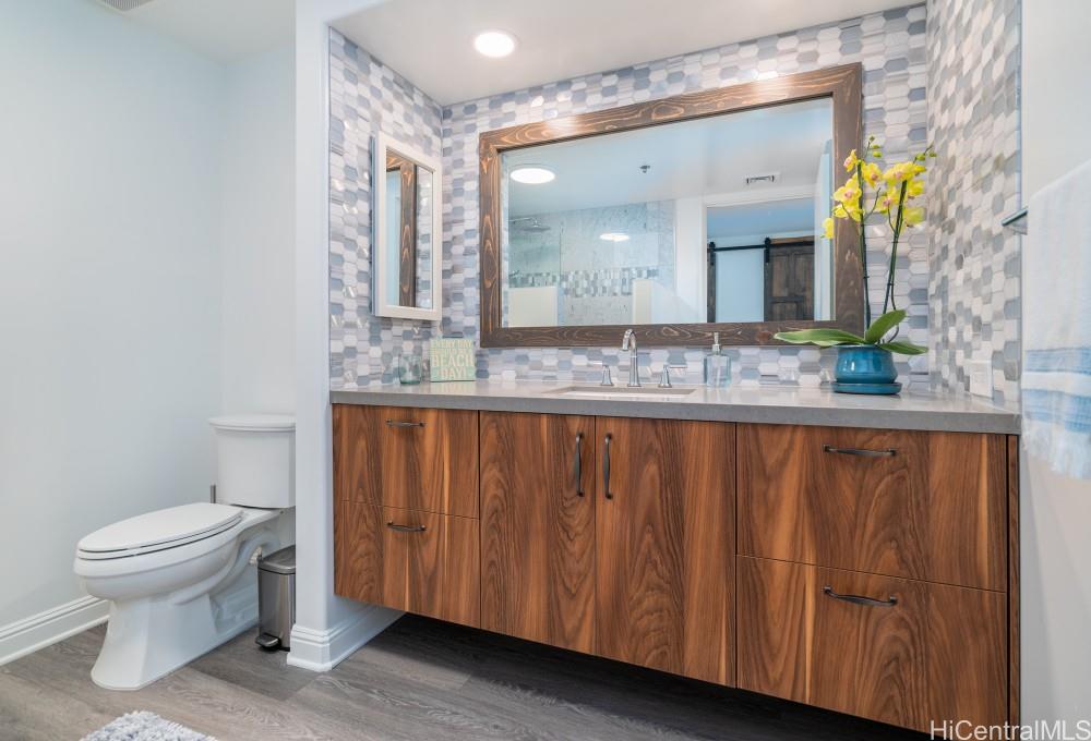 1 Keahole Place, Unit 3512 Honolulu, HI 96825 - Photo 15 of 18 a bathroom with a granite countertop sink and a mirror