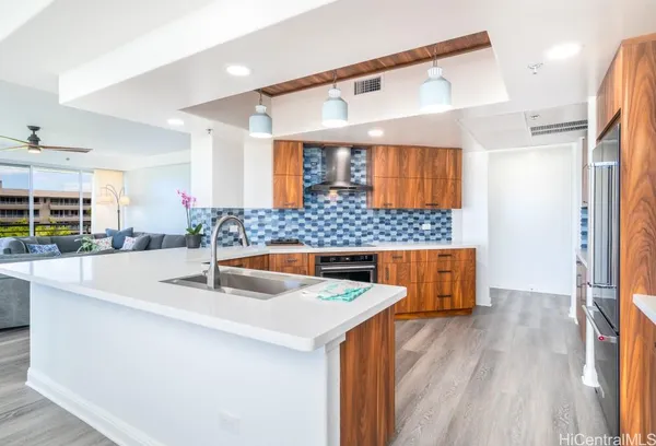a kitchen with stainless steel appliances granite countertop a sink and wooden floor