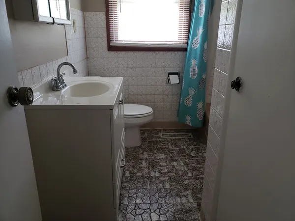 a bathroom with a toilet sink and a mirror