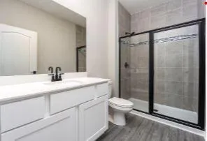 a bathroom with a shower sink vanity mirror and toilet