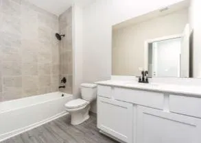 a bathroom with a sink a toilet and a large mirror