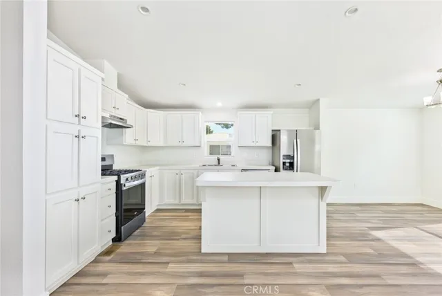 a kitchen with stainless steel appliances a sink stove and cabinets