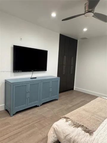a bedroom with a bed and a ceiling fan
