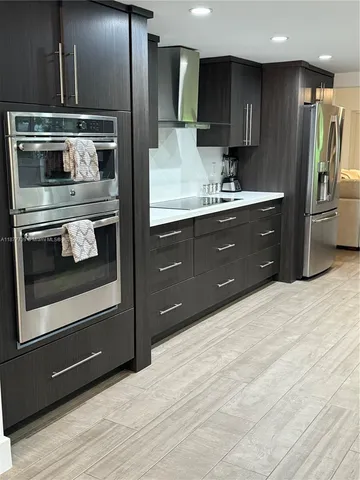 a kitchen with stainless steel appliances granite countertop a sink a stove and a refrigerator