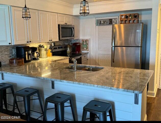 23223 Front Beach Road, Unit 703 Panama City Beach, FL 32413 - Photo 12 of 34 a kitchen with stainless steel appliances granite countertop a sink refrigerator and microwave
