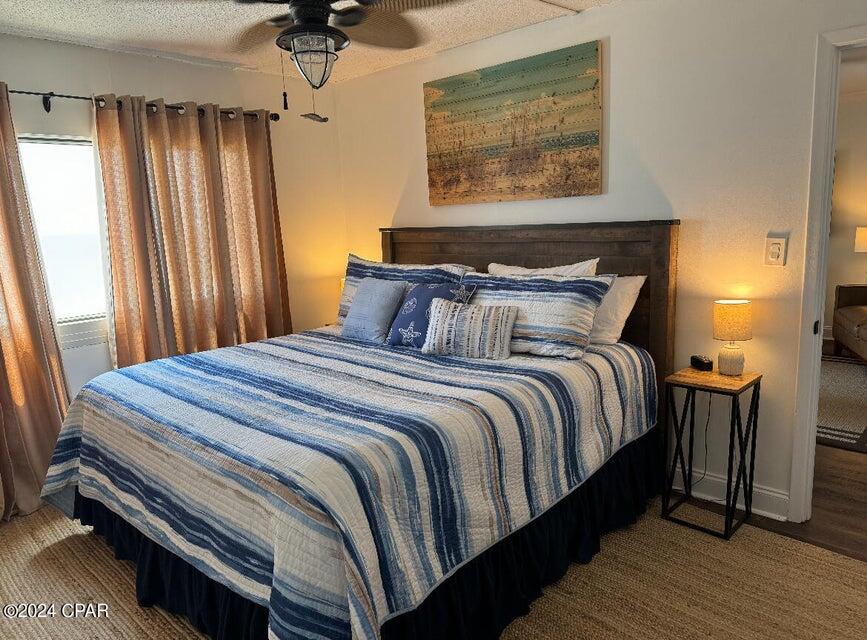 23223 Front Beach Road, Unit 703 Panama City Beach, FL 32413 - Photo 21 of 34 a bedroom with a bed and wooden floor