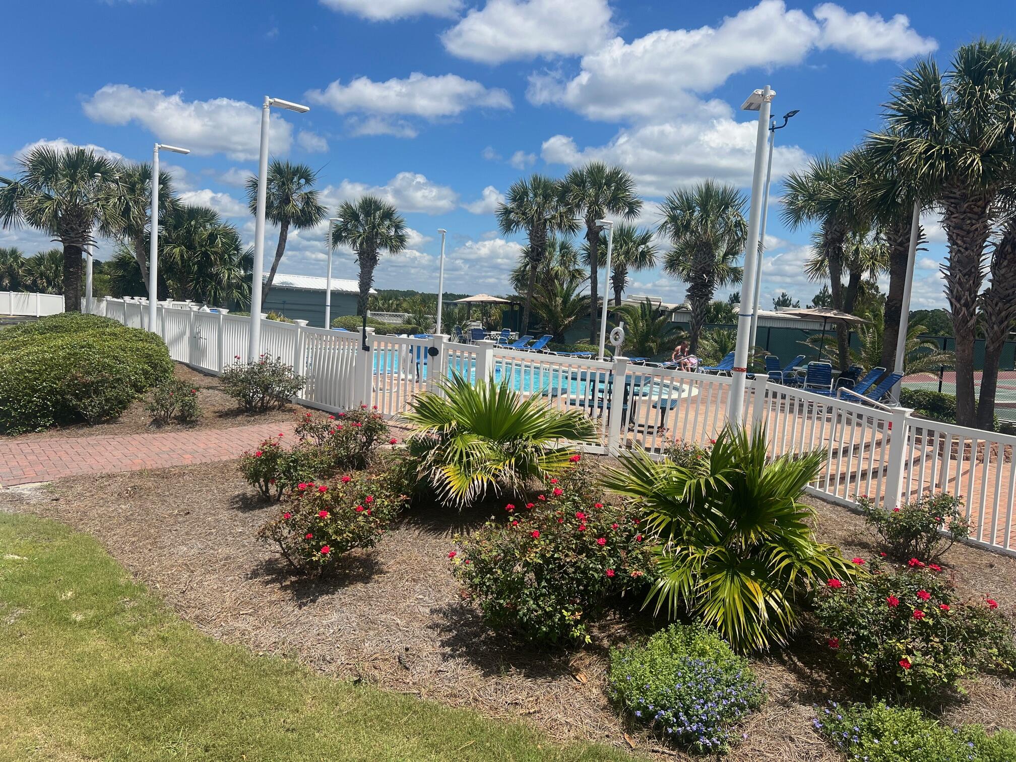 23223 Front Beach Road, Unit 703 Panama City Beach, FL 32413 - Photo 29 of 34 a view of a garden with a bench