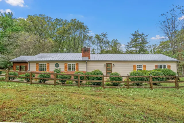 a view of a house with a big yard and large trees