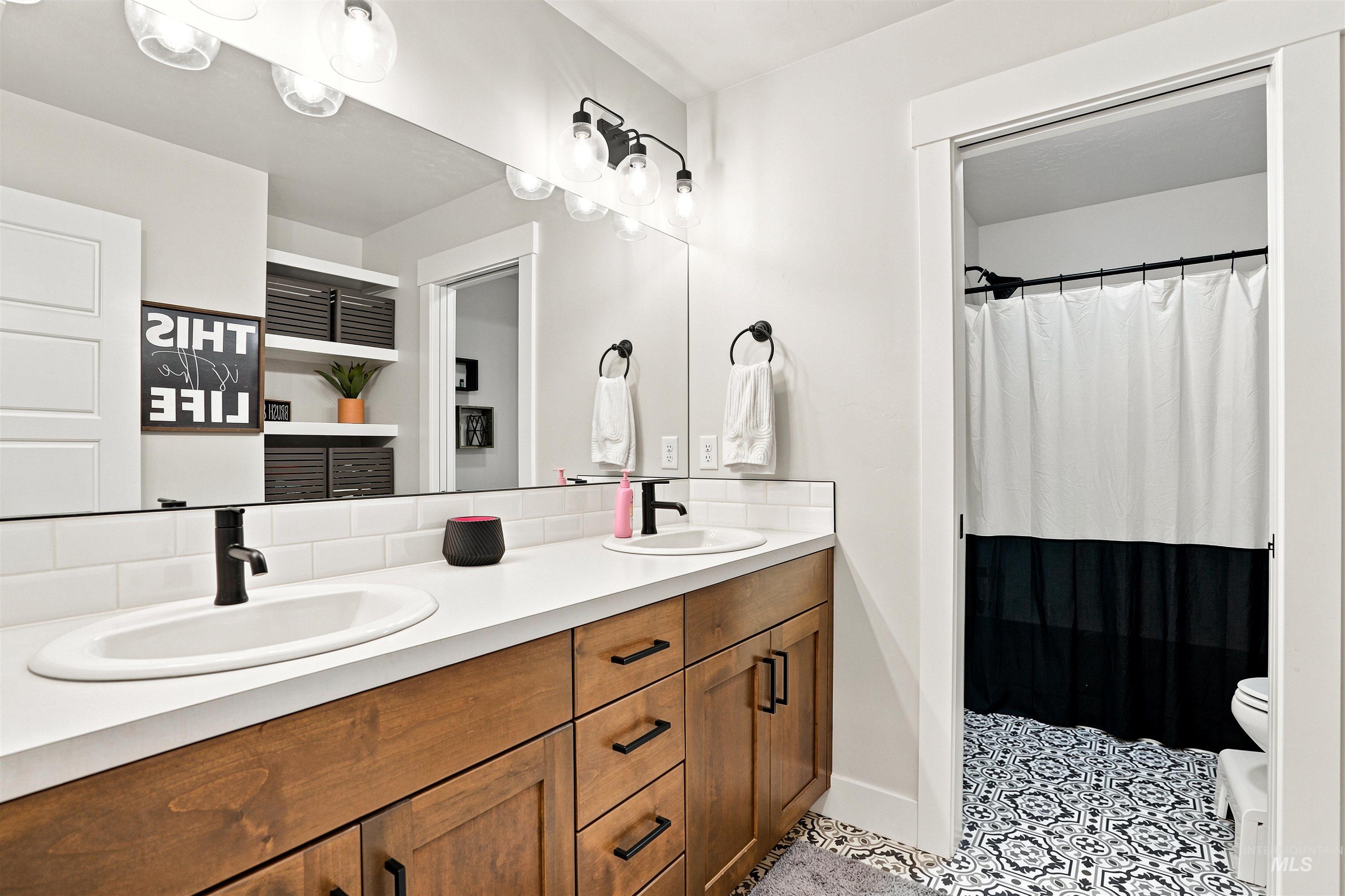 4323 West Ladle Rpds Drive Meridian, ID 83646 - Photo 32 of 49 Double vanity with wood-finish cabinetry, white countertops, and matte black fixtures