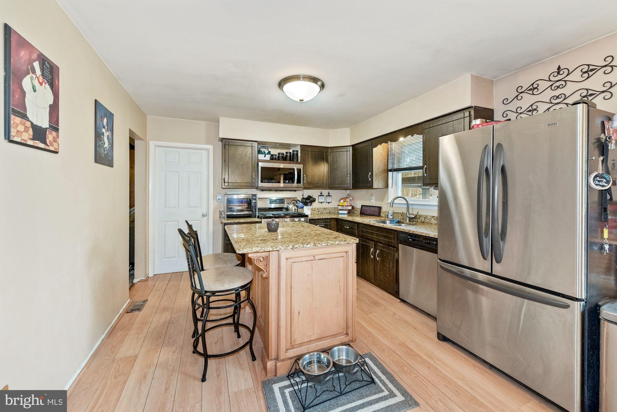 374 Holly Road Marlton, NJ 08053 - Photo 6 of 28 a kitchen with a refrigerator a stove top oven a sink dishwasher and white cabinets with wooden floor